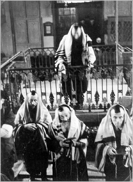 Jews wrapped in prayer shawls and phylacteries during prayer in the Radom ghetto synagogue.